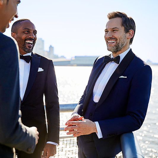man wearing blue tux with waterfront background