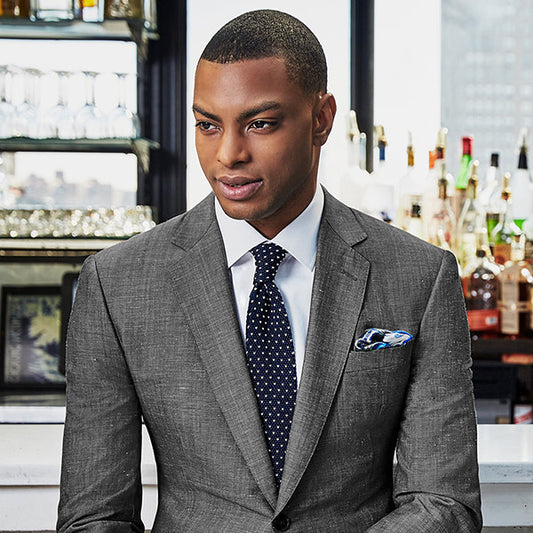man wearing a gray suit in a bar
