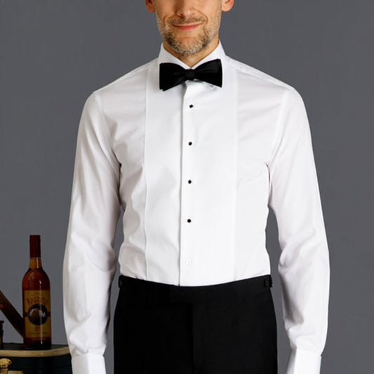 man wearing a tuxedo shirt on dark gray background