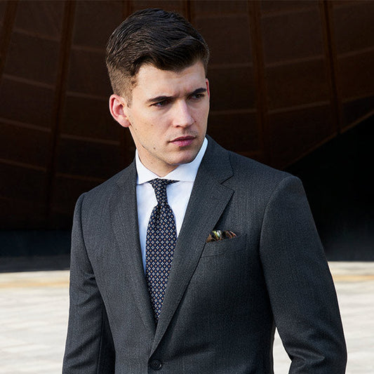 man wearing a gray suit standing outside