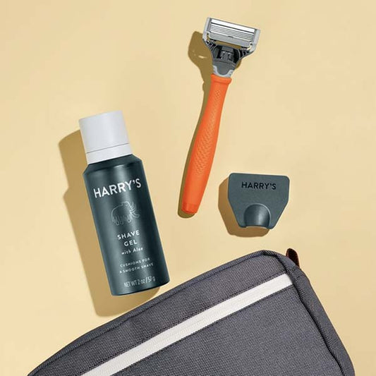 dopp kit bag with shave gel and razor on yellow background