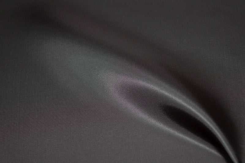 Close-up of dark gray bemberg fabric with a subtle texture