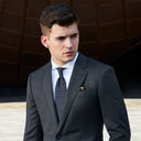 man wearing a gray suit standing outside